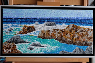 “Carmel,” a 20″x10″ framed acrylic canvas, brilliantly executed in pointillism by Ron Sanford, depicts the rugged beauty of Carmel’s coastline. The textured dots bring the crashing azure waves and sunbathed rocks to life, creating a harmonious interplay between the vibrant sea and the enduring shore.