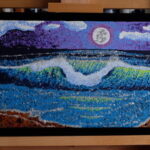 “Silver Moon,” a captivating 20″x10″ acrylic on canvas by Ron Sanford, depicts a nocturnal seascape, where a luminous moon casts its silver glow over undulating waves. The pointillist technique creates a shimmering effect, as if moonlight is dancing on the water’s surface and the rugged coastline.