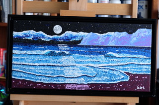 “Moonlit Shoreline” is a 30″x10″ acrylic canvas where Ron Sanford uses pointillism to illuminate the nocturnal dance of light on water. Here, the moon reigns over serpentine waves, casting a silvery path across the dark sea, while stars sprinkle the night sky, all framed and signed, capturing the quiet drama of the night.
