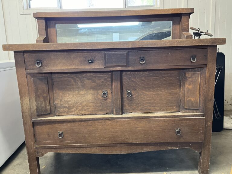 This antique oak buffet features sturdy construction with a rich patina, traditional brass pulls, and a complementary framed mirror, embodying early 20th-century utilitarian design and craftsmanship. Solid Wood American Made of Oak, circa 1930s. Empire Furniture Company, Huntington, West Virginia, with Label.