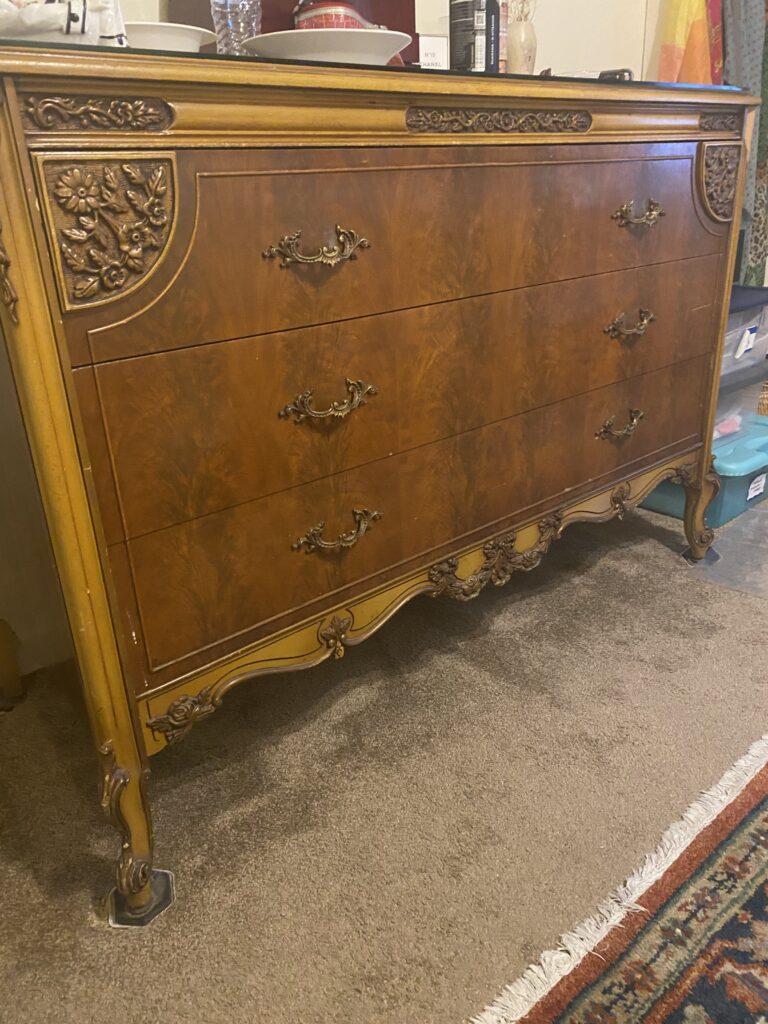 This French Provincial dresser showcases ornate brass hardware and detailed carvings on fruitwood. Elegant curves and a warm patina highlight its early 20th-century craftsmanship. Hand Made in American, Tiger Oak Wood.